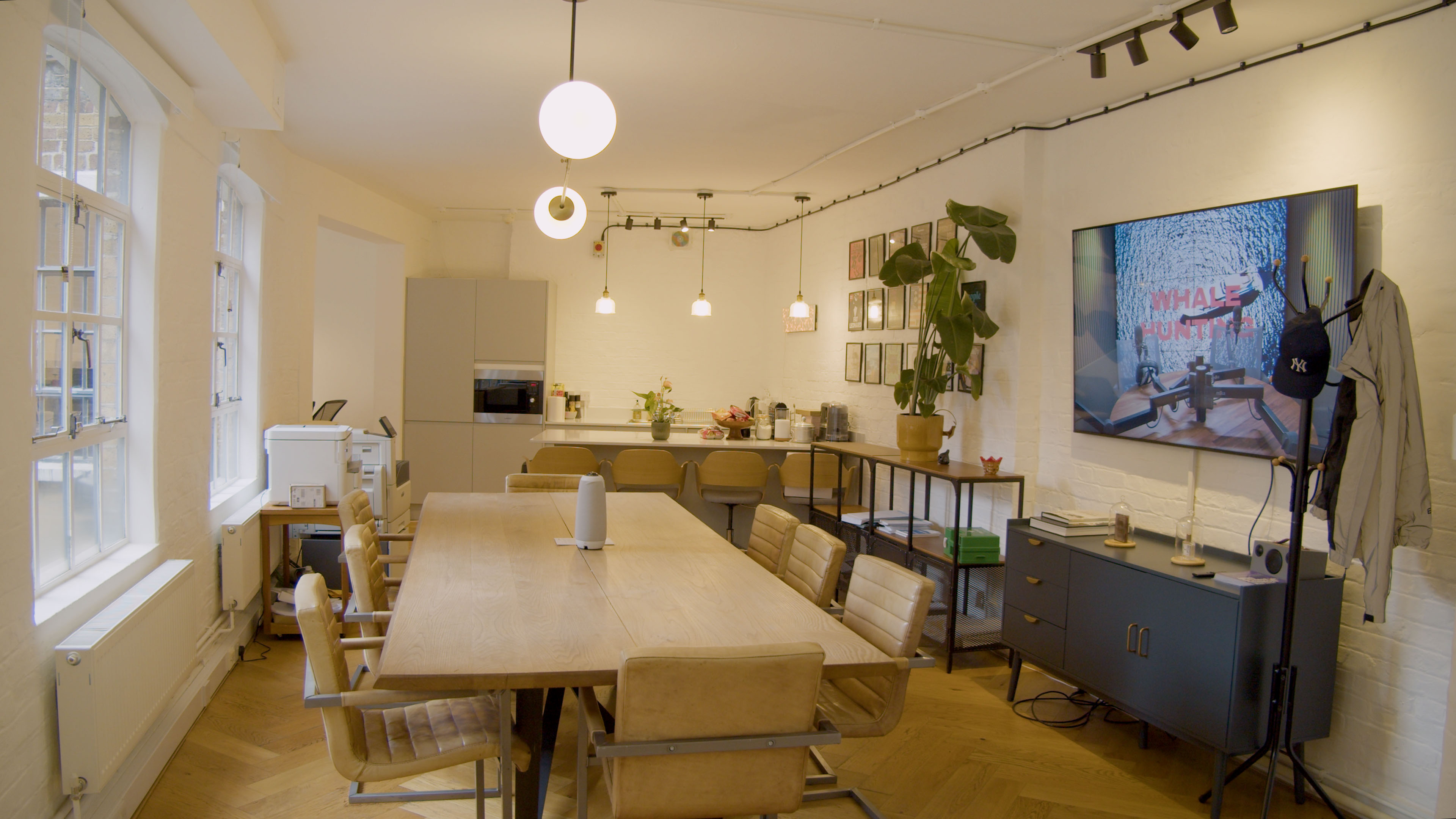 Brazen Studios client viewing suite: conference-style table with 8 seats and large display screen for live playback monitoring, available at our content creation studio in London.